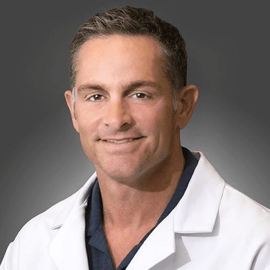 A man in white lab coat smiling for the camera.